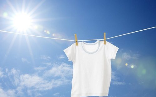 A snow-white T-shirt is drying outside on a rope