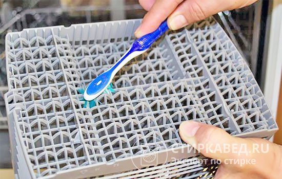 Cleaning the basket from dirt with a toothbrush
