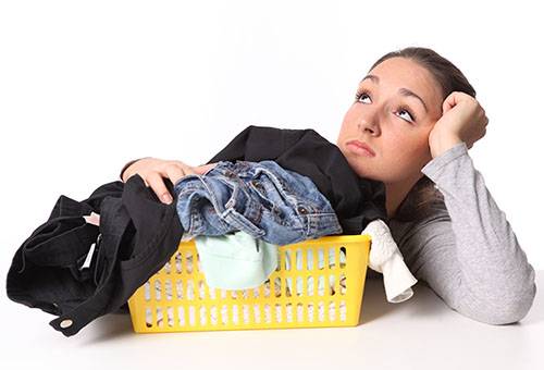 A girl thinks about how to wash jeans and trousers