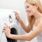 Девушка отключает стиральную машину