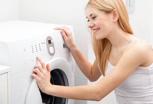 Девушка отключает стиральную машину