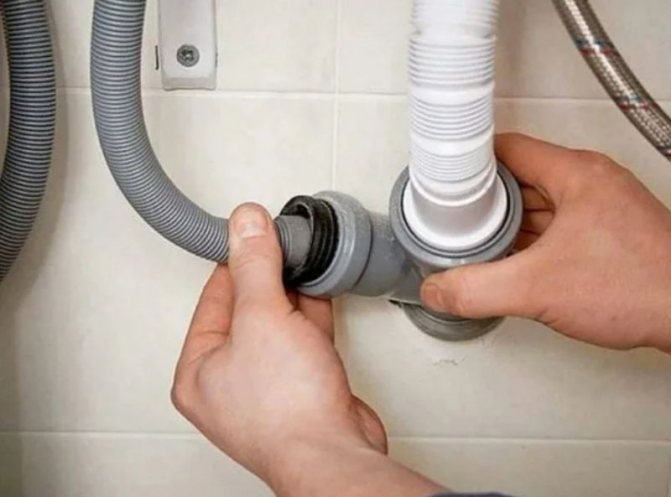 A man connects a water drain hose