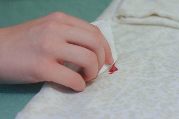 Removing red nail polish stain from white fabric