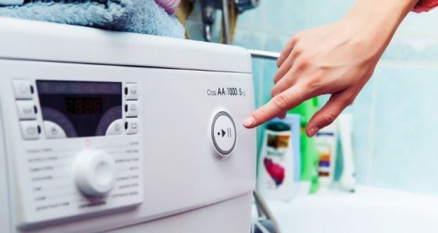 Woman turns on the washing machine